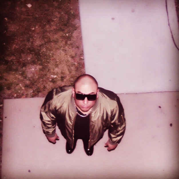 Фото Высокоугольный портрет человека в солнцезащитных очках, стоящего на тротуаре