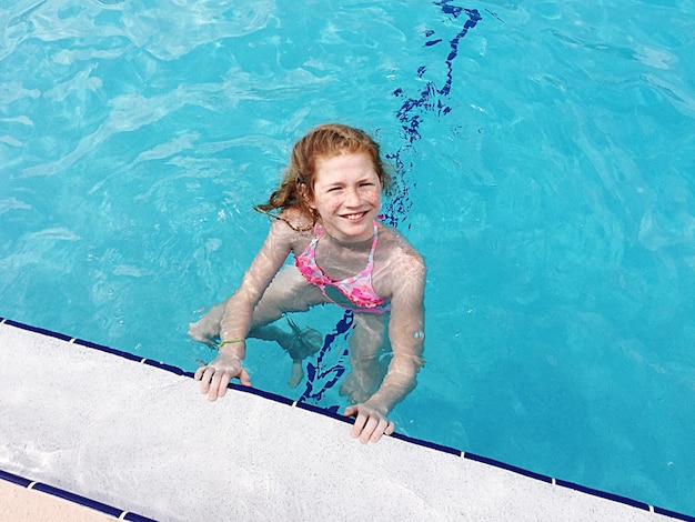 high angle portrait of smiling girl in swimming pool