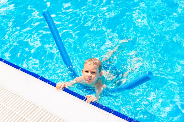 High angle portrait of smiling woman swimming in pool