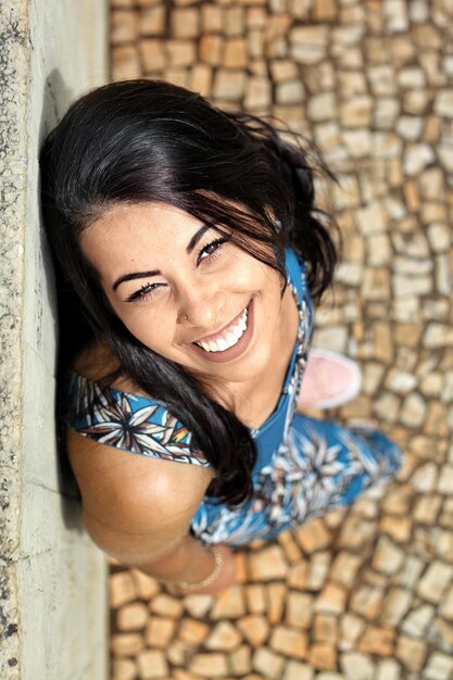 Foto ritratto ad alto angolo di una giovane donna sorridente in piedi all'aperto