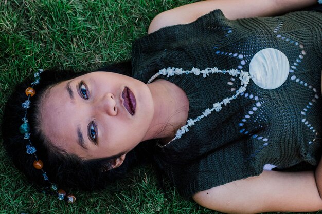 Photo high angle portrait of teenage girl with make-up lying on grassy land