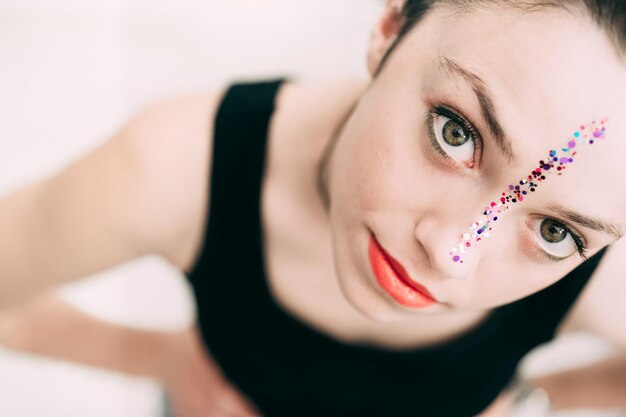 Photo high angle portrait of woman with glitter on her face against white background