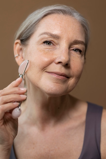 Photo high angle senior woman using gua sha