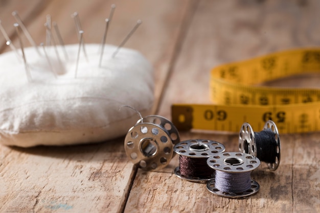 Photo high angle of sewing machine shuttles with needles and measuring tape