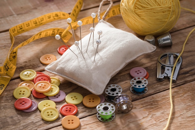 Foto alto angolo di aghi per cucire con filo e bottoni