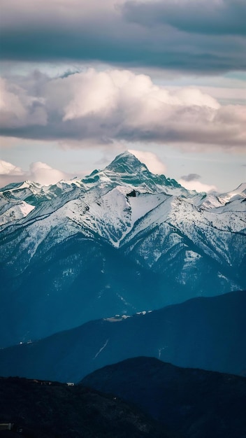 High angle shot of a beautiful mountain range covered with snow under the cloudy sky