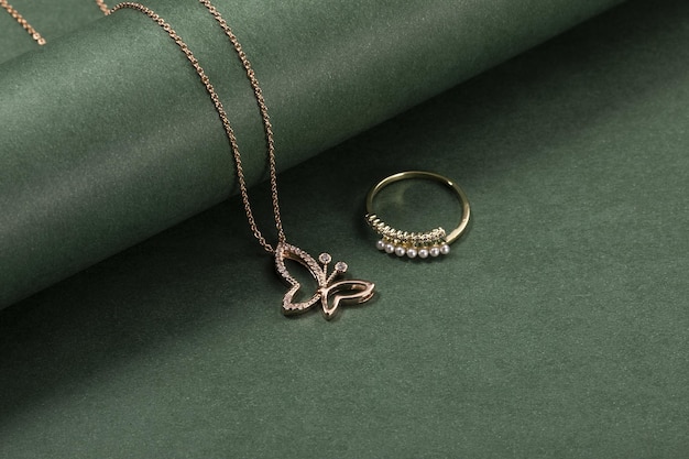 A high angle shot of a beautiful ring and necklace on a green surface