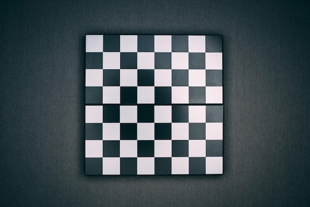 High angle shot of a checkered chessboard on a black surface