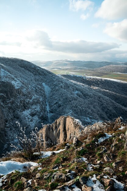 High angle shot of the high hill mountains covered with little snow in the daytime