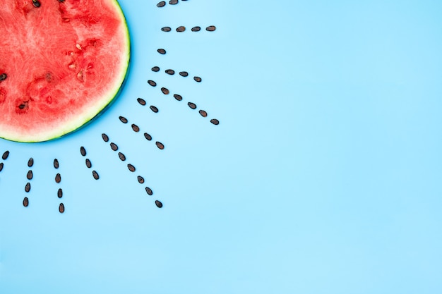 Photo high angle shot of a slice of watermelon and the seeds on a blue surface