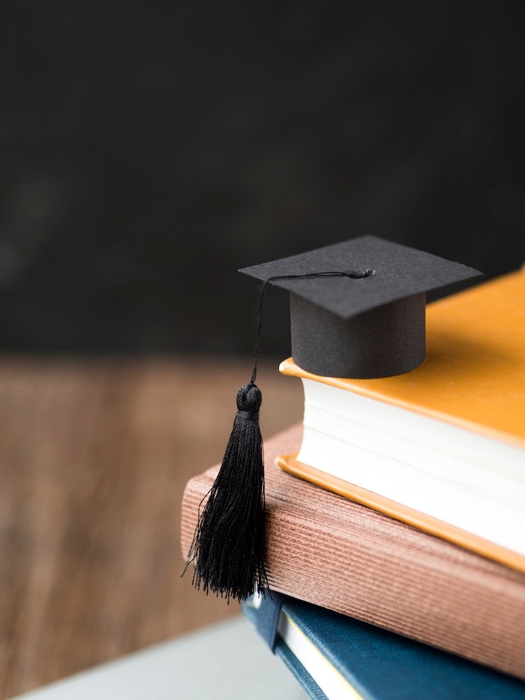 Photo high angle small graduation cap on pile of books