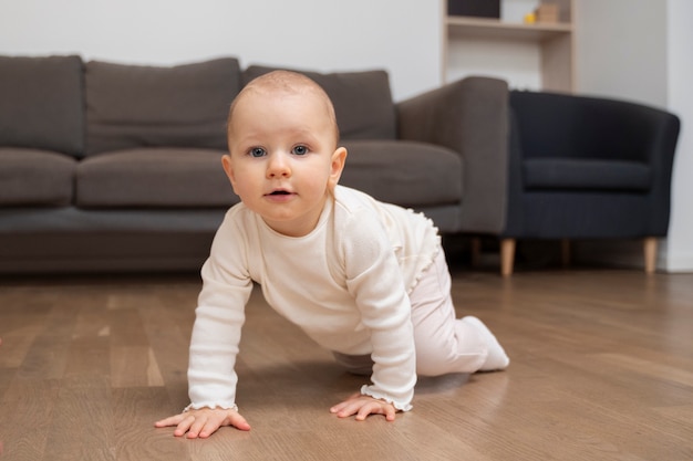 Foto bambino sorridente ad alto angolo che striscia sul pavimento