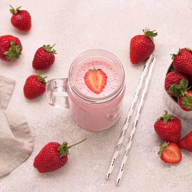 High angle of strawberry milkshake with straws