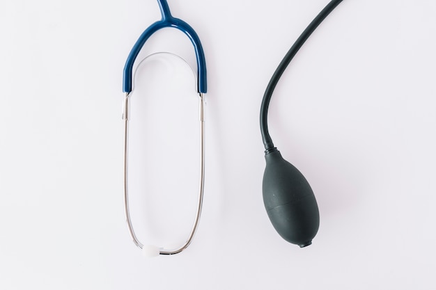 High angle view of air inflating bulb and stethoscope on white surface