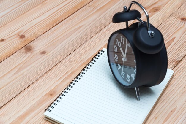 Photo high angle view of alarm clock over book on table