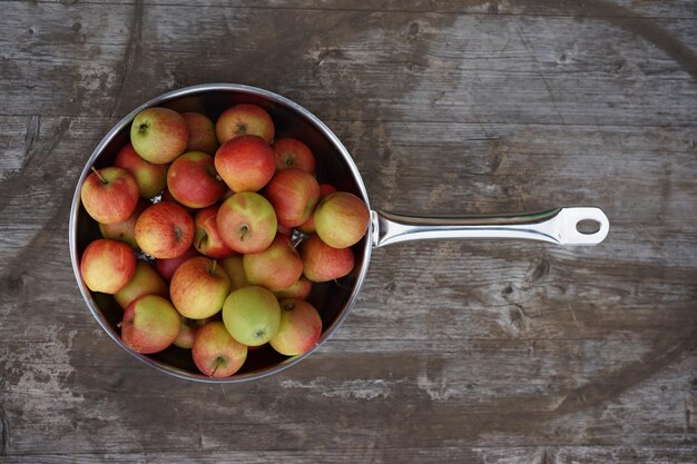 High angle view of apples in pan on wooden table