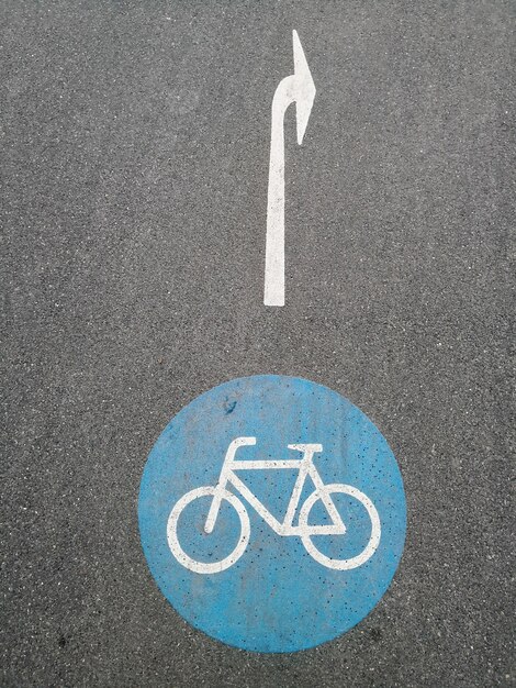 Photo high angle view of arrow and bicycle signs on road