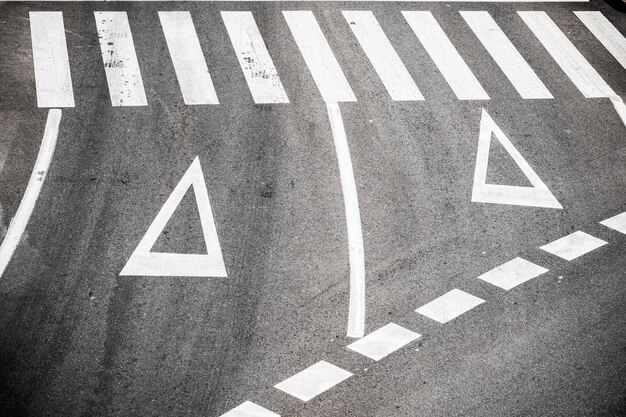 Photo high angle view of arrow symbols and crosswalk on road