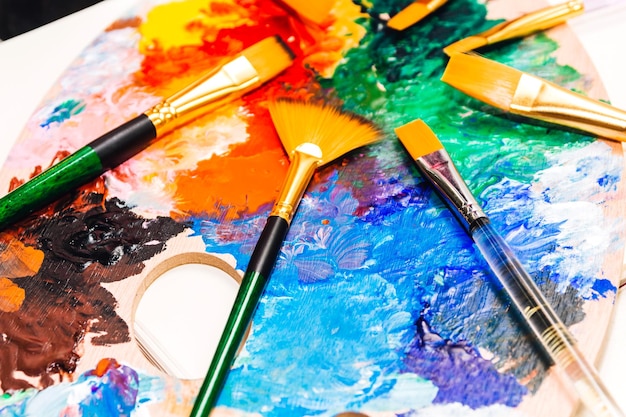 Photo high angle view of artist palette with paintbrushes on table