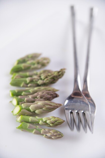 High angle view of asparagus in plate against white background