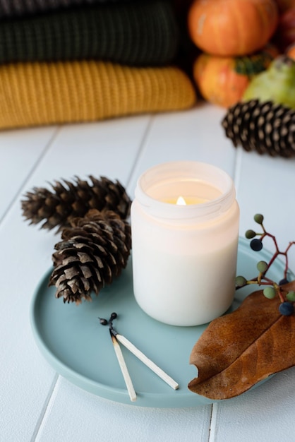 High angle view autumn composition with sweaters and candles\
white candle mockup design