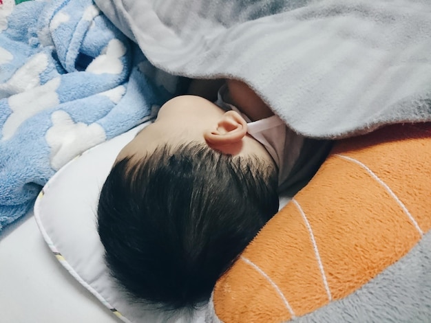 Photo high angle view of baby boy sleeping on bed at home