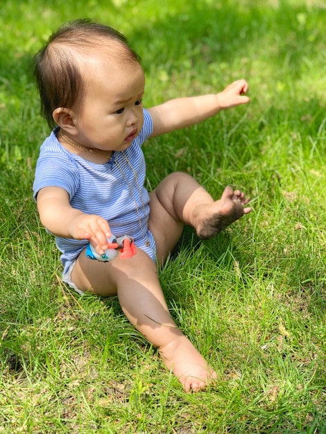 Photo high angle view of baby girl sitting on grassy field