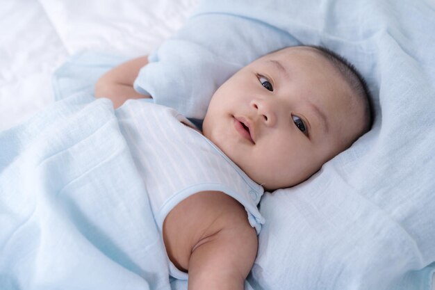 High angle view of baby lying on bed