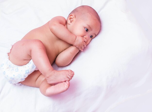 High angle view of baby lying on bed