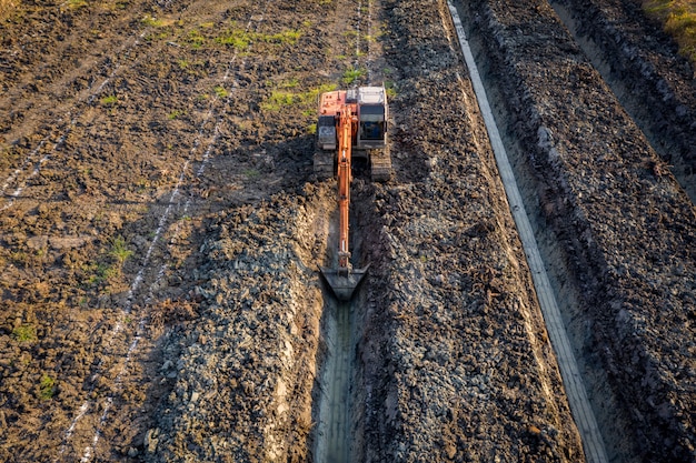 High angle view backhoe is dingging the groove garden and agricultural area Thailand 