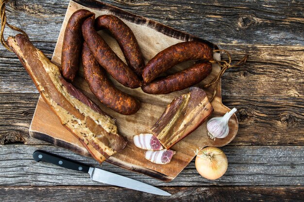 High angle view of bacon and sausages on cutting board