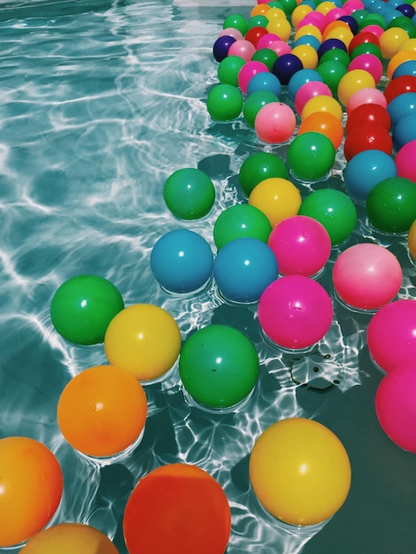 Photo high angle view of balls floating on water in swimming pool