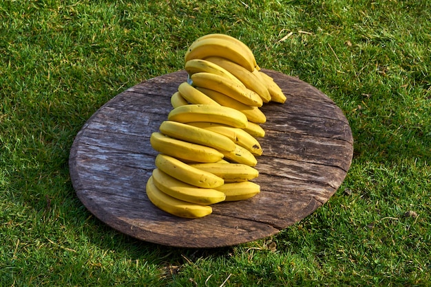 Photo high angle view of bananas on wood at grassy field