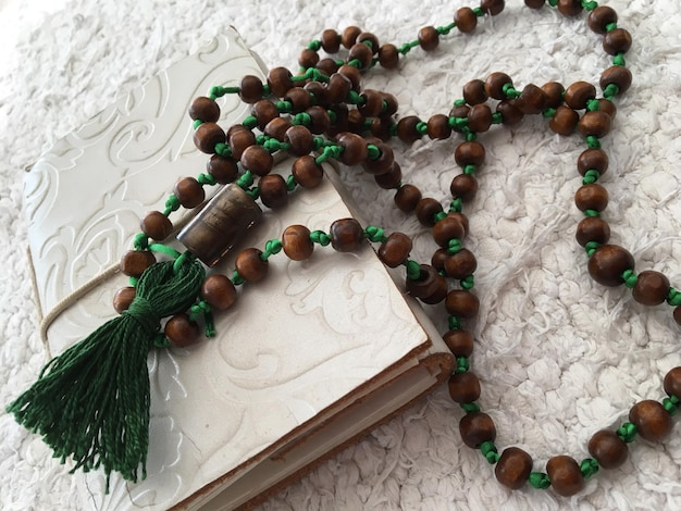 High angle view of bead necklace over book