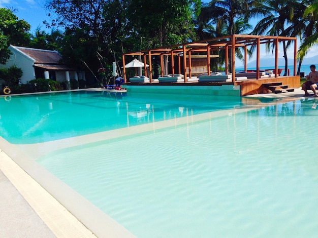 High angle view of beds by swimming pool against palm trees