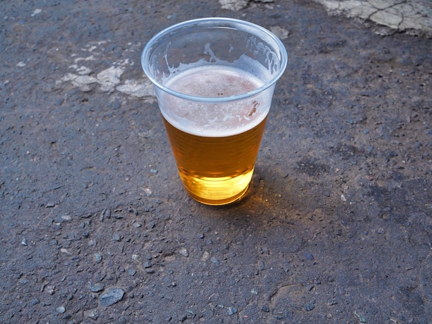 Foto vista ad alto angolo del bicchiere di birra sulla strada