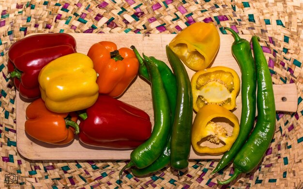 Photo high angle view of bell peppers and chili peppers in whicker basket
