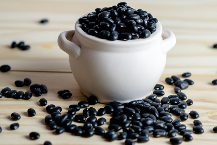 Photo テーブルの上の黒いコーヒー豆の高角度のビュー