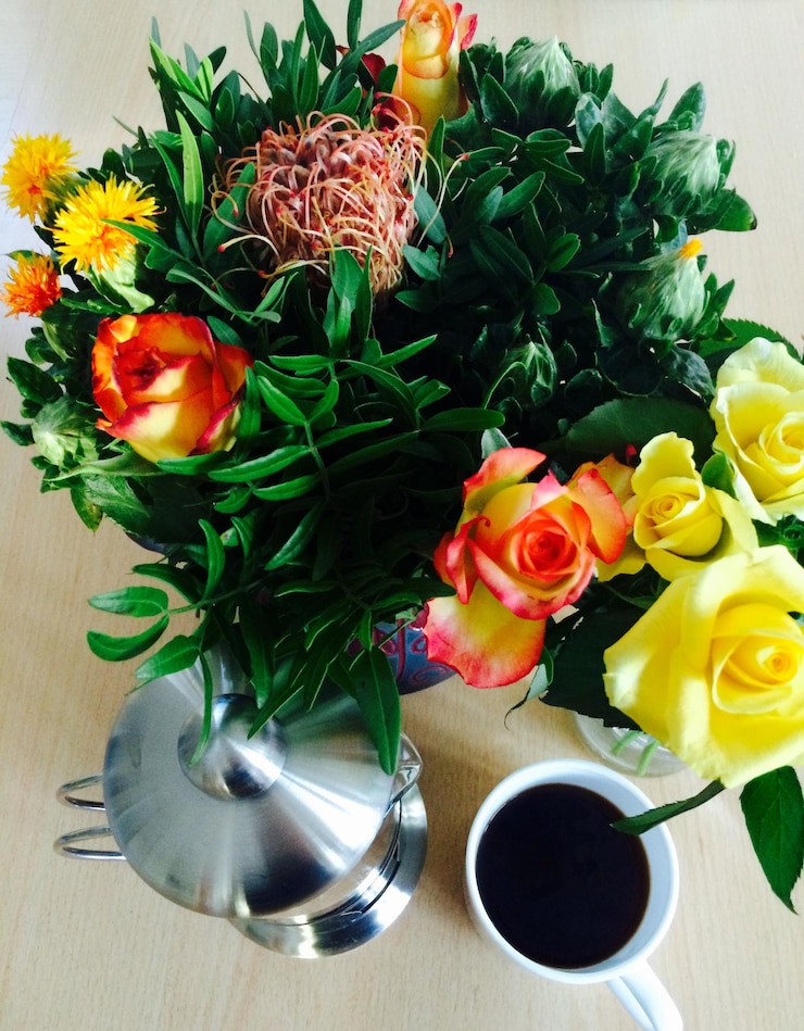Photo high angle view of black coffee with kettle and flower bouquet