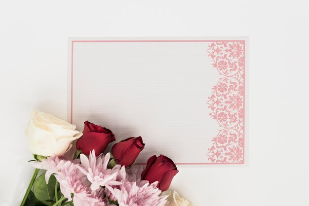 Photo high angle view of blank card with beautiful roses on white backdrop