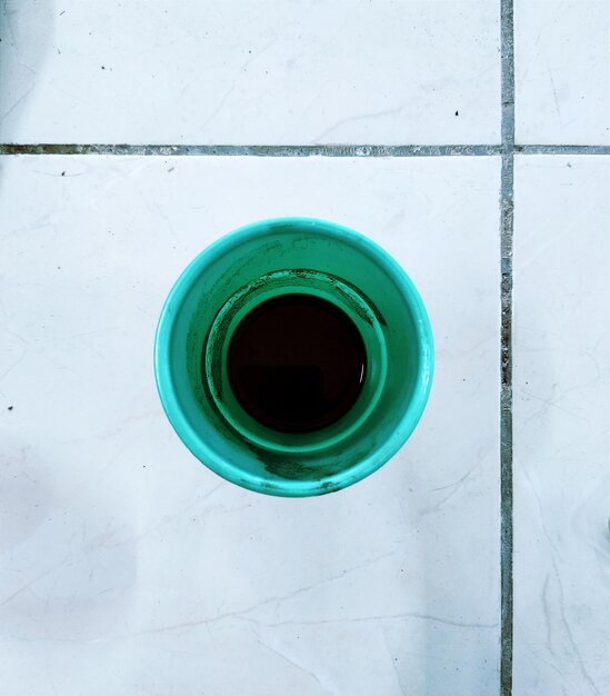 High angle view of blue cup on tiled floor