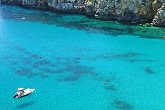 Foto vista ad alta angolazione di una barca ormeggiata in mare da montagne rocciose