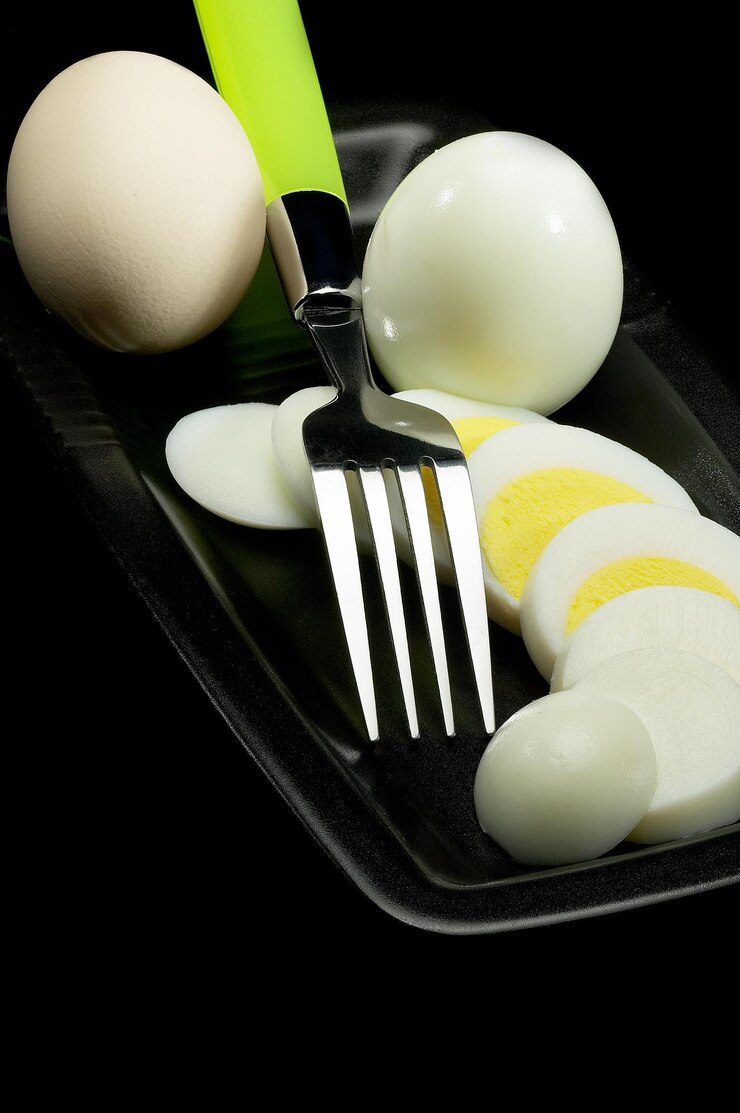 Photo high angle view of boiled eggs in plate on black background