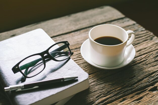 Photo high angle view of book with coffee on wooden table