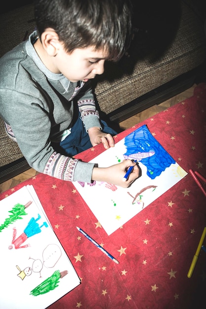 Photo high angle view of boy drawing on paper