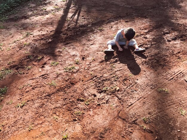 Foto vista ad alta angolazione di un ragazzo seduto sul campo