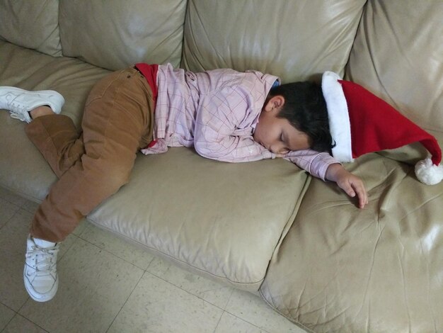 Photo high angle view of boy sleeping on bed at home