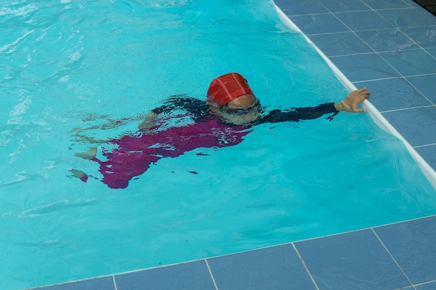 Foto vista ad alta angolazione di un ragazzo che nuota in piscina