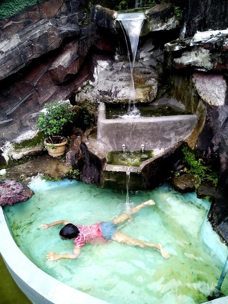 Foto vista ad alta angolazione di un ragazzo che nuota in piscina