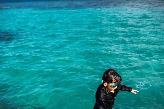 Foto vista ad alta angolazione di un ragazzo che nuota in mare